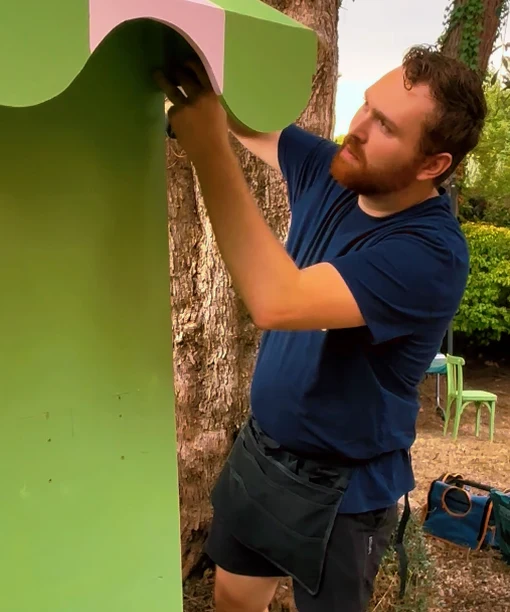 Thibault Agius installe l'auvent rayé du comptoir des petites douceurs